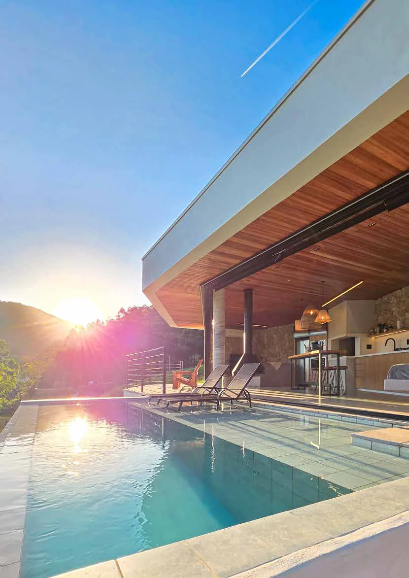 Piscina e varanda da casa com as montanhas da serra ao fundo